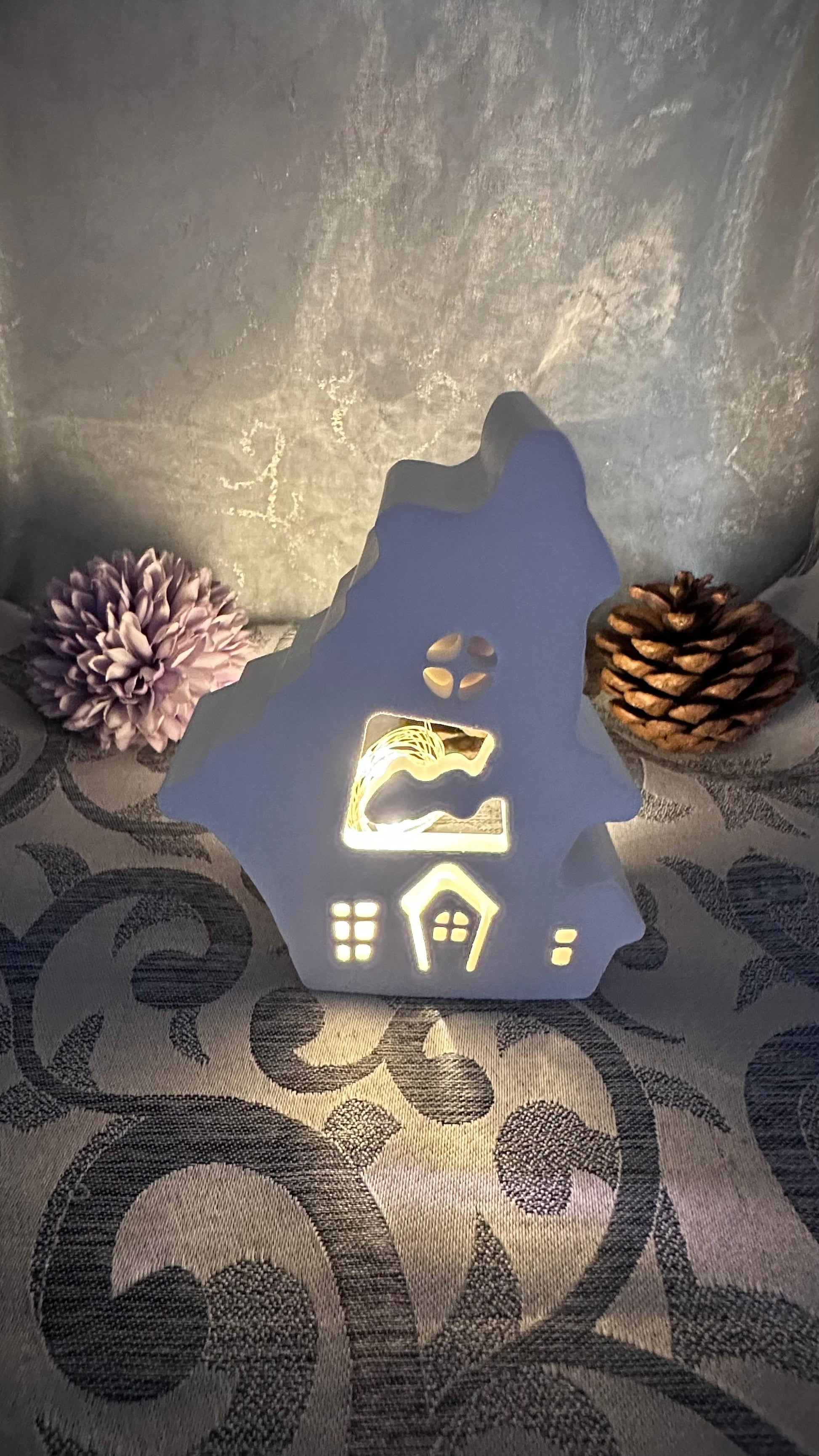 Leuchtendes Keracraft-Haus mit Wolkenmotiv und ausgeschnittenen Fenstern.