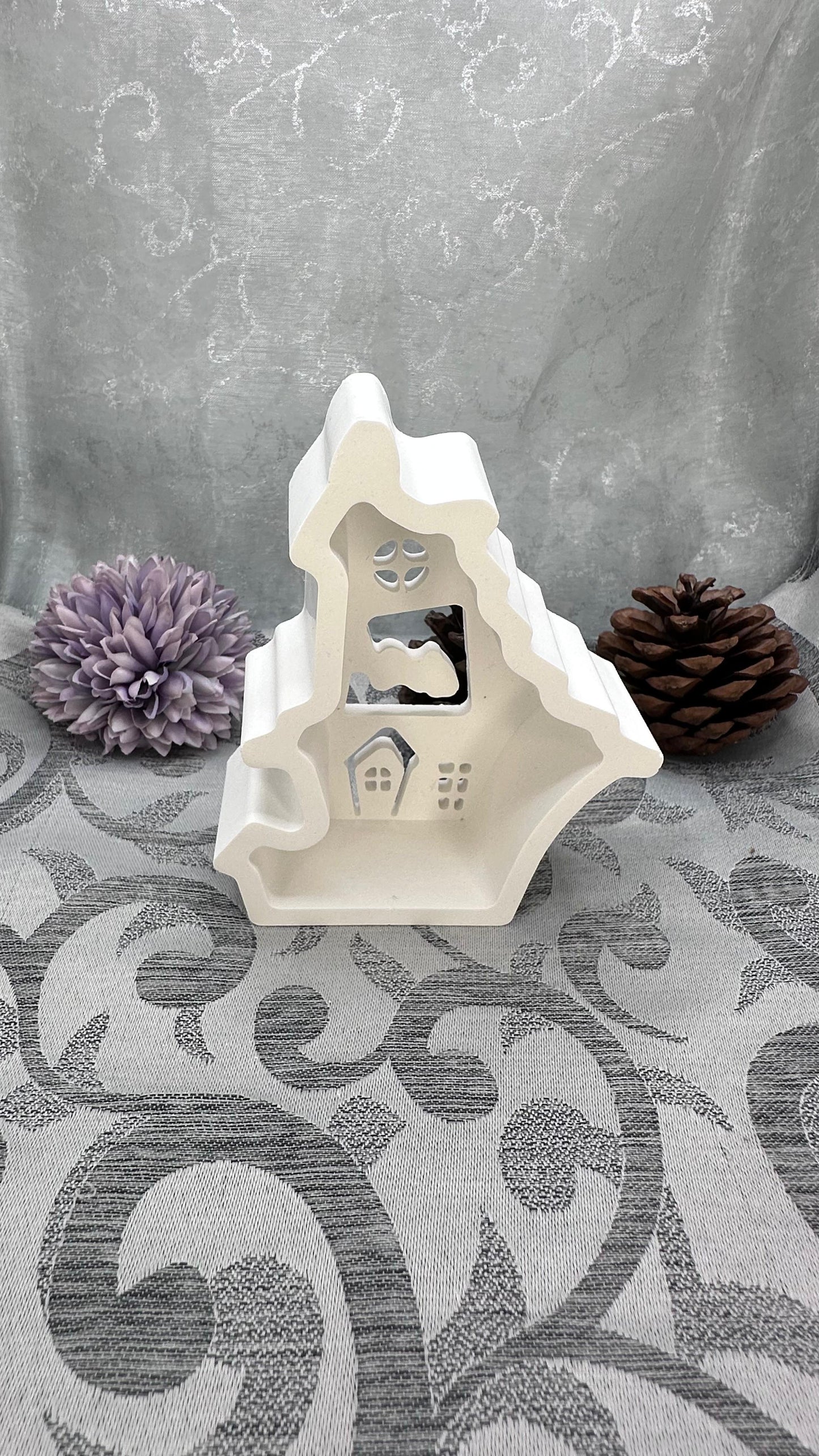 Keracraft-Haus mit Wolkenmotiv und ausgeschnittenen Fenstern.
Herzberg Crafts