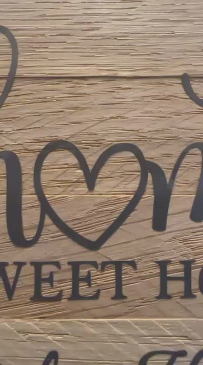 Video von Handgefertigtes Deko-Türschild mit weißem Keracraftring, Vinylschriftzug auf Holzklötzchen ‚home sweet home bei den Herzis‘ und Burgundy Makramee-Anhänger, an weißer Wand.
Herzberg Crafts